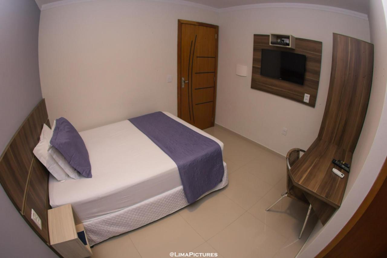 Quarto de casal com TV na parede e ar-condicionado